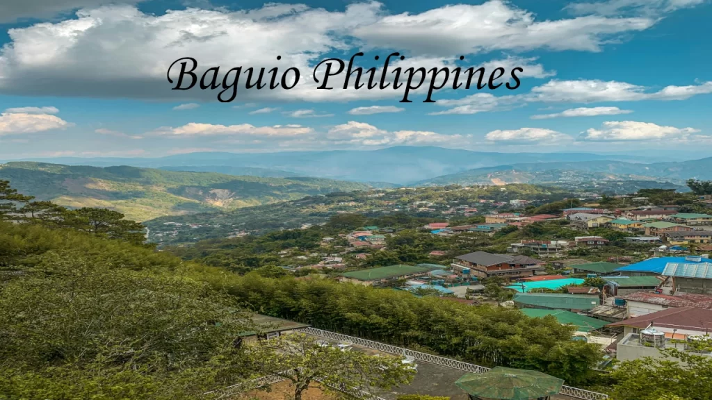 A wide scenic overlook of Baguio City's colorful valley communities surrounded by rolling green hills.