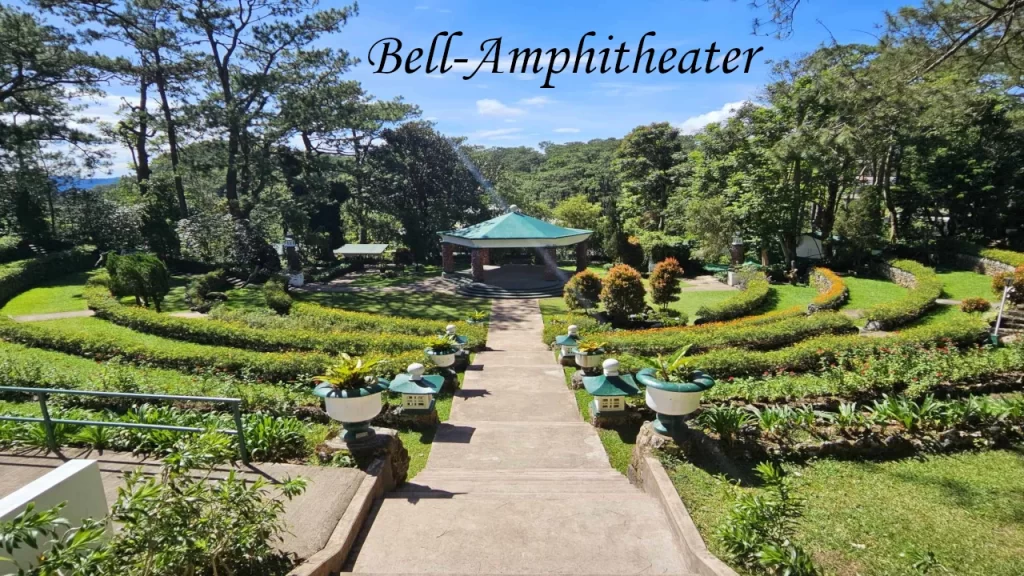 A beautifully terraced circular stone amphitheater surrounded by pine trees in Baguio hill stations.