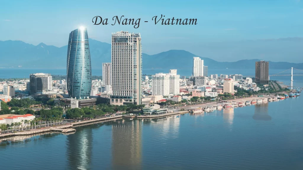 Aerial view of Da Nang city skyline along the Han River waterfront with mountains in the background — a rising destination wedding location in Vietnam