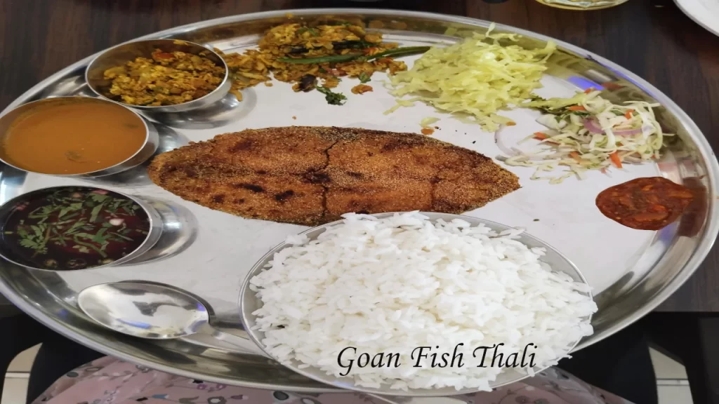 Traditional Goan fish thali served on a steel plate with fried fish, steamed rice, fish curry, salad and chutneys — a must-try meal on a Goa with Family holiday