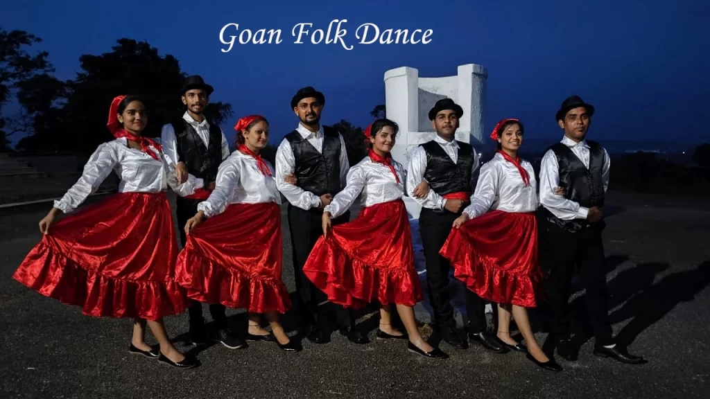 Goan folk dancers in traditional red skirts and black vests performing the Mando dance — a cultural highlight for Goa with Family visits