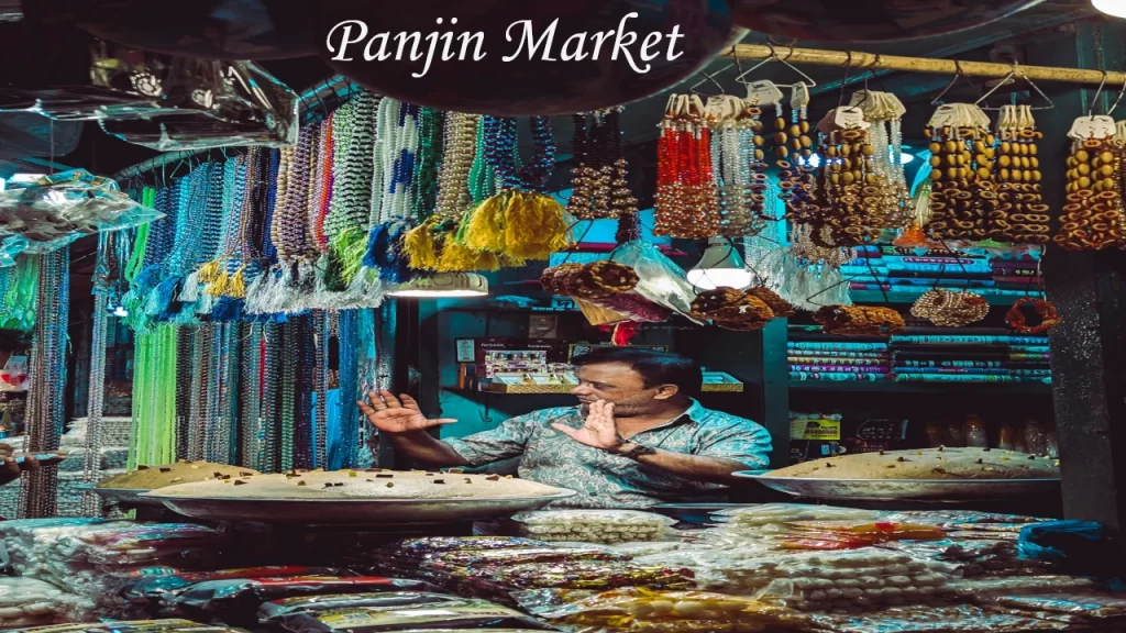 A local vendor showcasing handmade beaded necklaces, spices, and traditional goods at a bustling market in Goa.