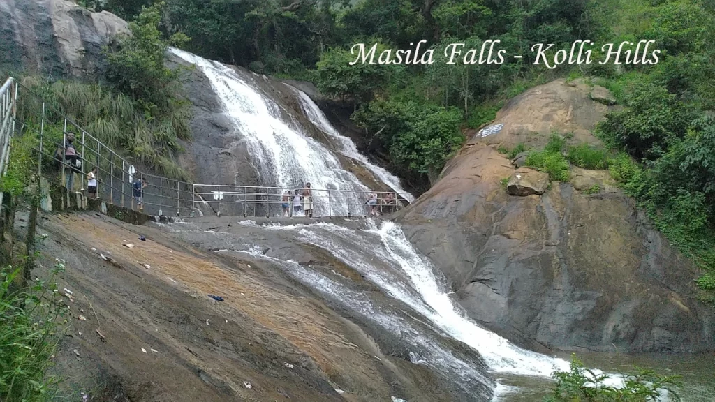 Visitors standing near the cascading Masila Falls in Kolli Hills, a scenic waterfall attraction at one of the hidden hill stations in Tamil Nadu