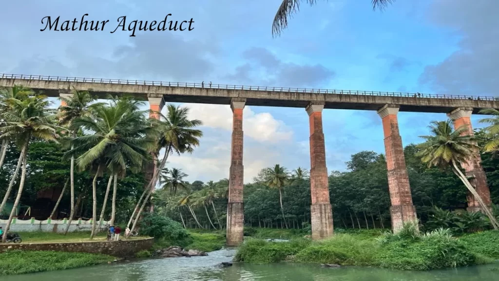 High-angle architecture of the Mathur Aqueduct standing over a river surrounded by lush greenery, a prime attraction for Kanyakumari Tourism.