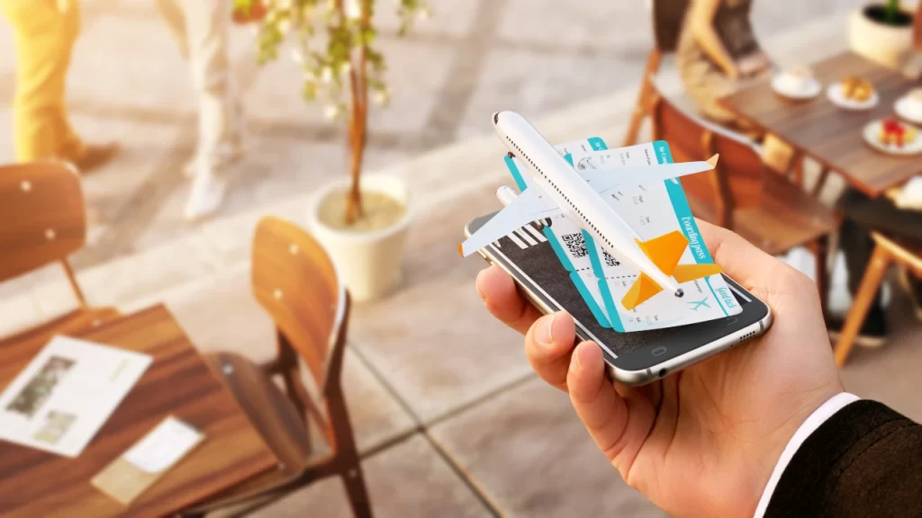 Hand holding a smartphone with a 3D airplane and digital boarding passes, showcasing modern flight booking tips using technology.