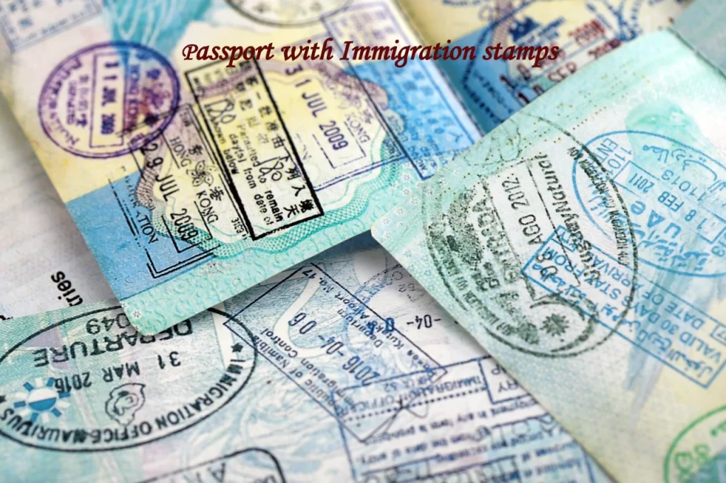 A close-up view of multiple physical passport pages overlapping, filled with colorful international immigration ink stamps and visas from various countries.