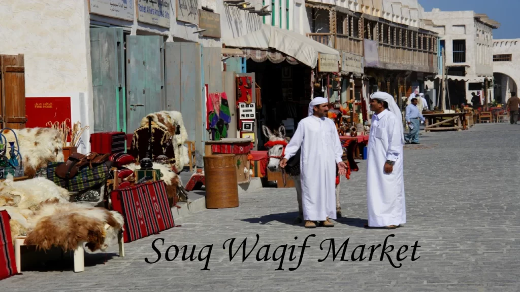 Outdoor market stalls filled with colorful lamps, traditional garments, and vibrant cultural artifacts at Souq Waqif, an essential cultural stop among places to visit in Doha.