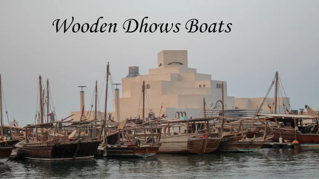 Classic wooden Dhow boats docked at the harbor along the waterfront with a modern skyline backdrop, highlighting unique coastal places to visit in Doha.