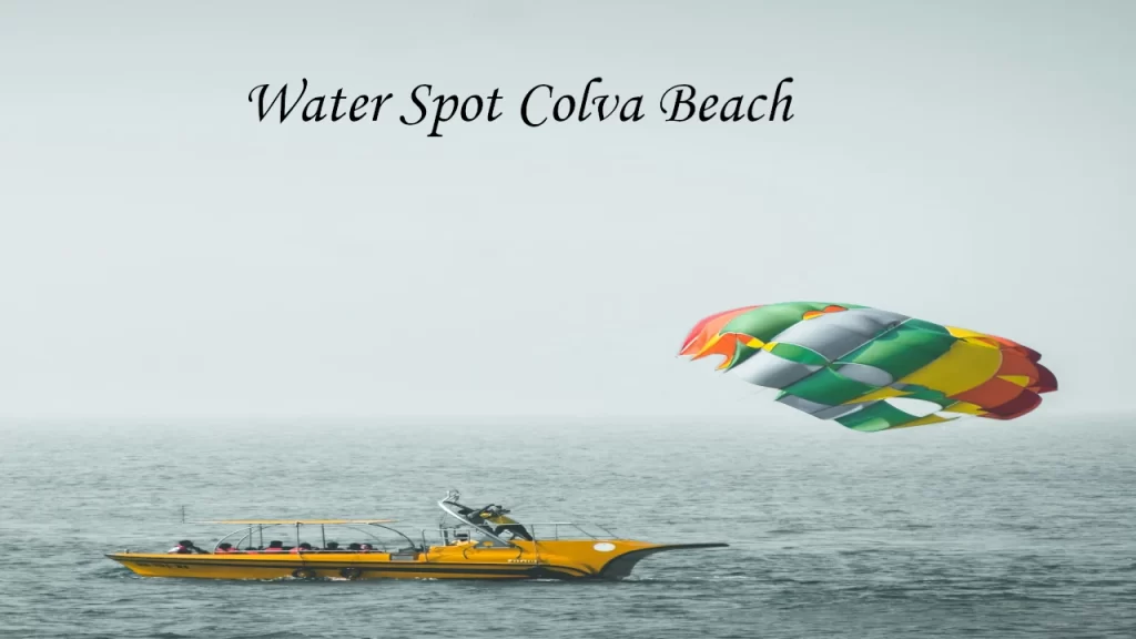 A yellow speed boat pulling a colorful parasail high above the ocean waters near Colva Beach in Goa.