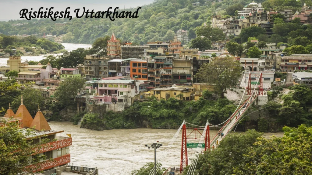 Indian Travel destination showcasing Rishikesh with the iconic Lakshman Jhula, the Ganges River, hillside temples, lush greenery, and vibrant town views.
