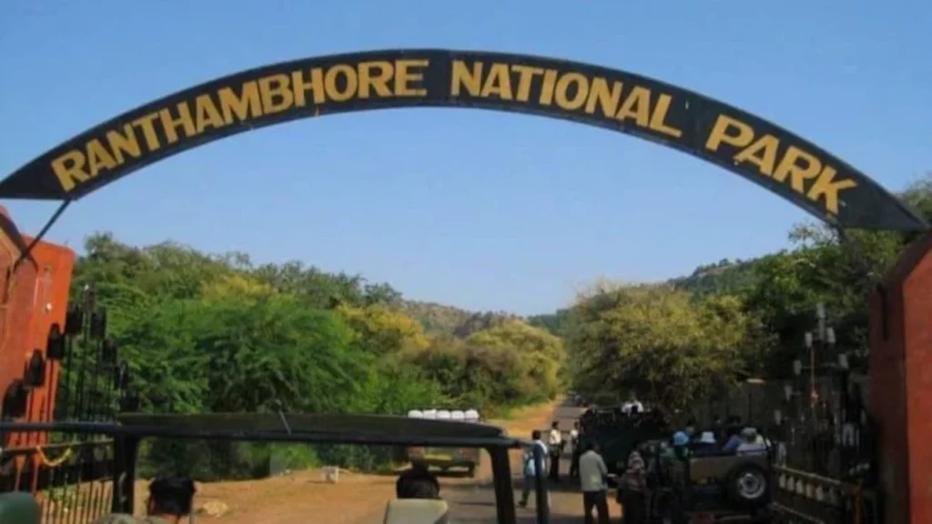 Arched entrance gate of Ranthambore National Park in Rajasthan, India, with safari jeeps and visitors at the entry point