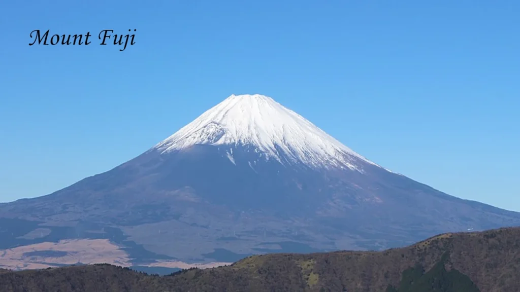 Snow capped Mount Fuji in Japan under a clear blue sky, a must visit landmark featured in every Japan travel itinerary.