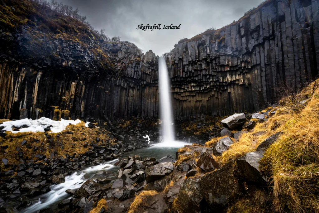Skaftafell Iceland waterfall surrounded by basalt columns and rocky cliffs